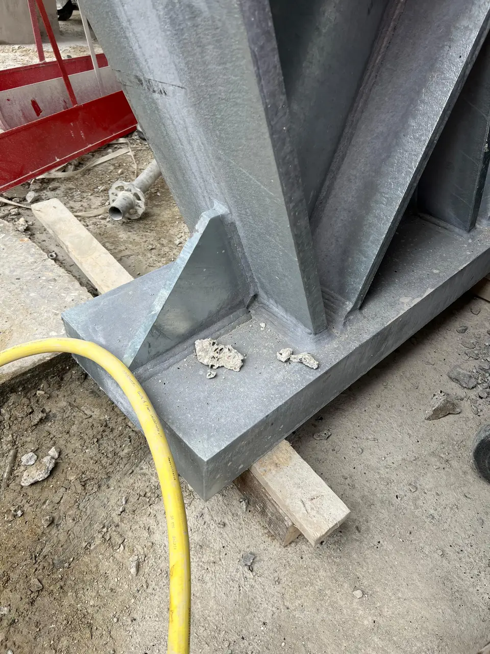 Détail de pied de renfort métallique, assise sur cale bois en phase de réglage.
