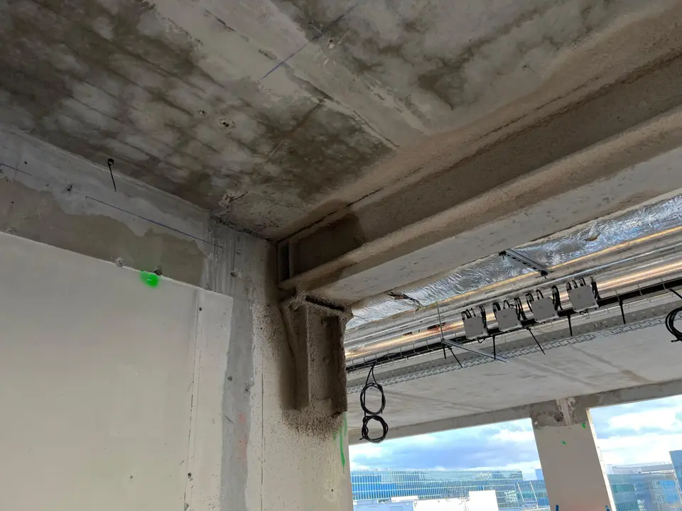 Reprise de poutre métallique en sous-face de plancher, au droit d'un angle de bâtiment.