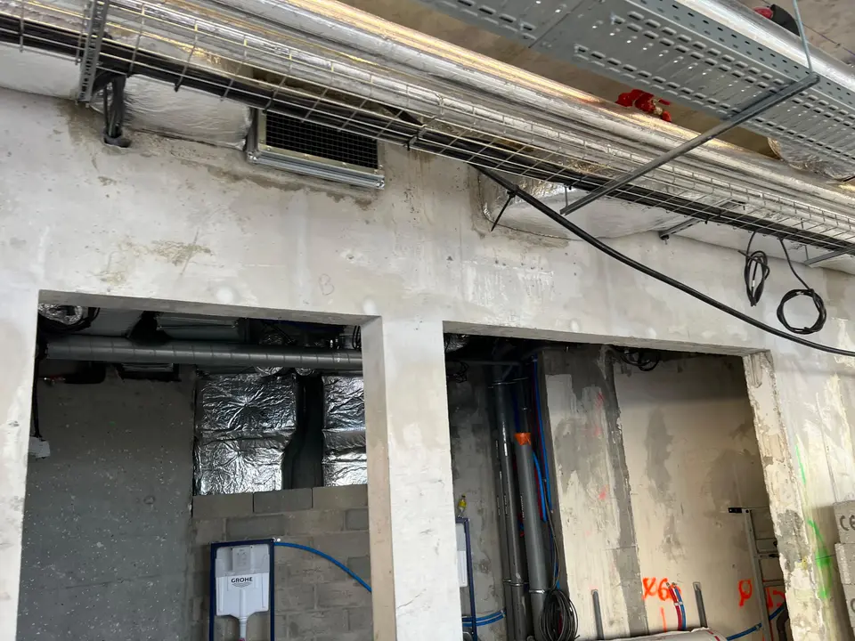 Intégration des réseaux techniques (CVC, électricité) au droit d'une retombée de poutre béton.