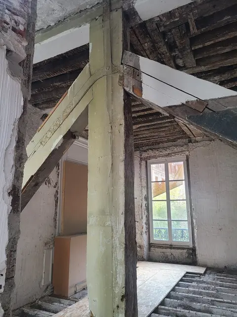 Charpente bois complexe en combles : poutres de faîtage, chevrons, solives — structure à caractériser avant toute intervention.