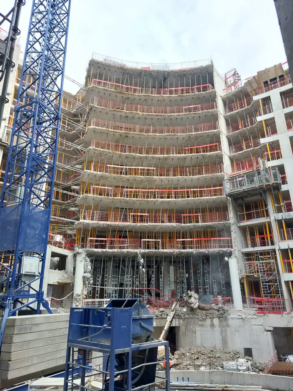 Opération comparable : façade courbe conservée toute hauteur, étaiée niveau par niveau pendant la démolition des planchers intérieurs.