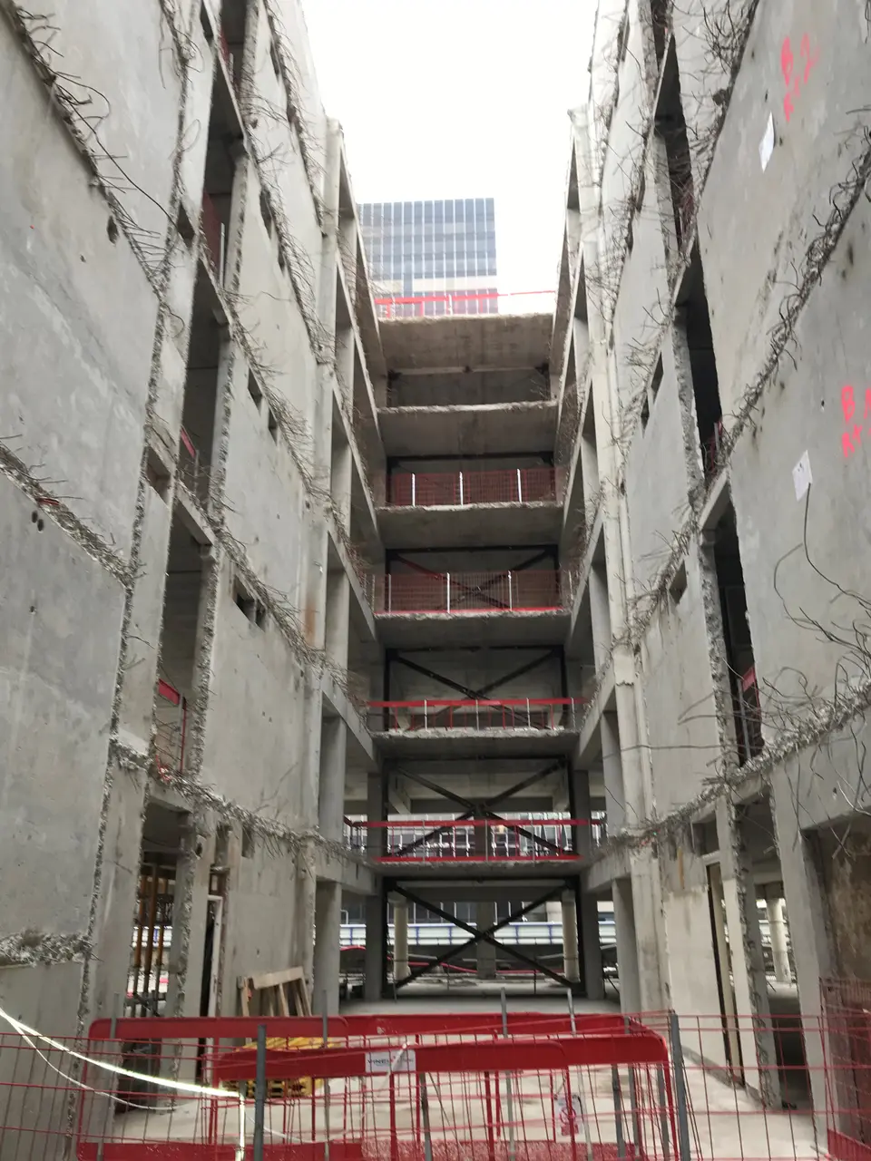 Vue d'ensemble depuis le bas du bâtiment — système de contreventement provisoire visible sur plusieurs niveaux successifs.