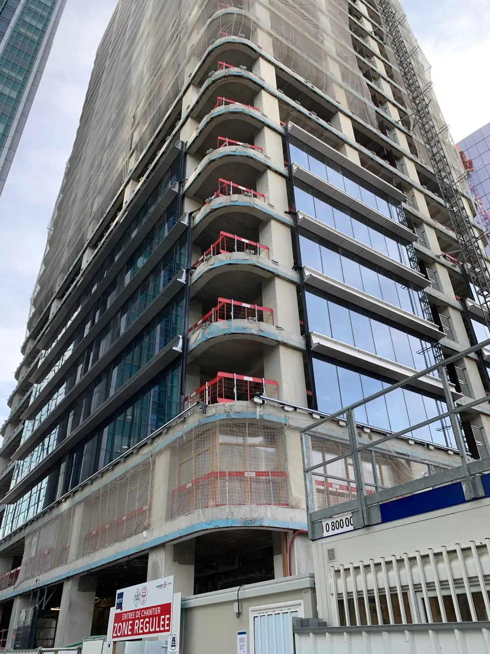 Façade du bâtiment mitoyen en cours de construction — vue de la base de la tour.