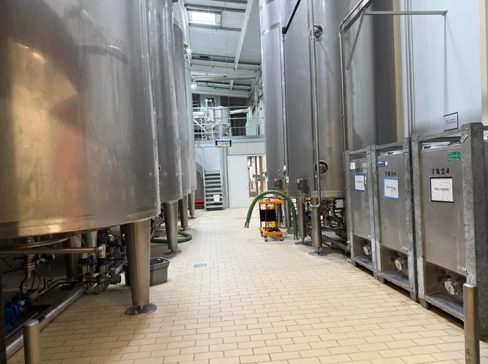 L'intérieur du bâtiment de production : charpente métallique existante et zones d'exploitation à maintenir pendant les travaux.